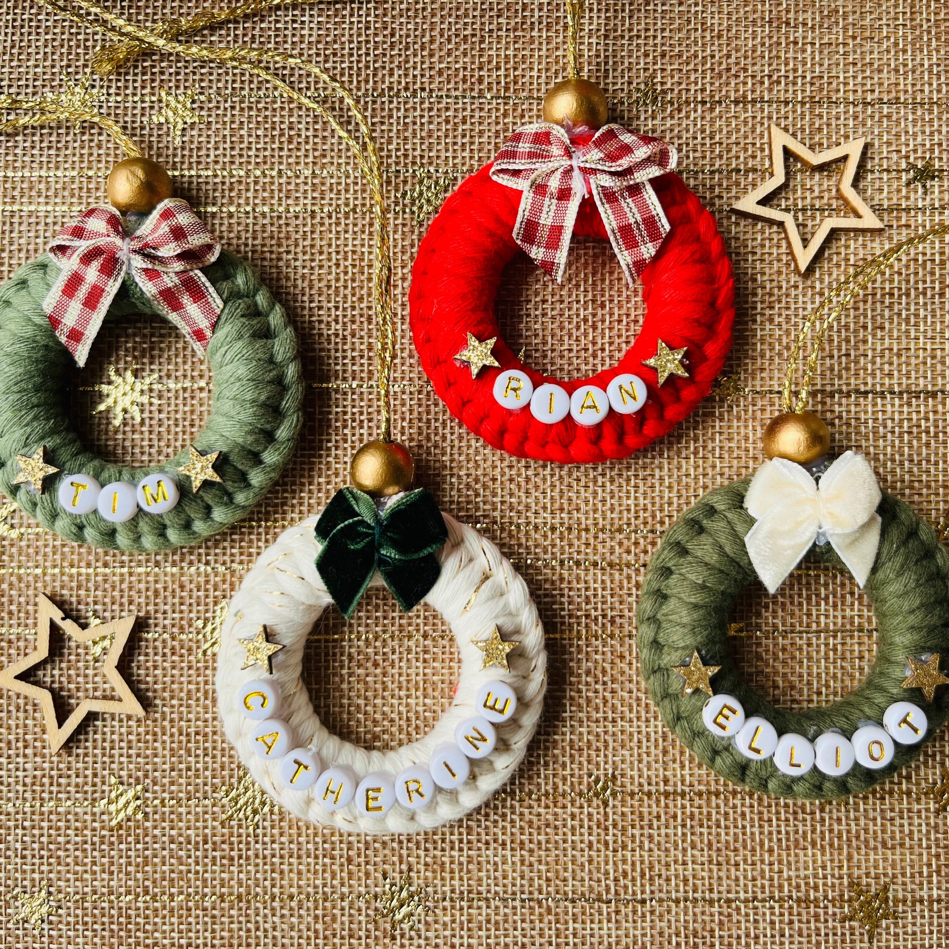 Set of small wreath ornaments with names on a textured fabric background