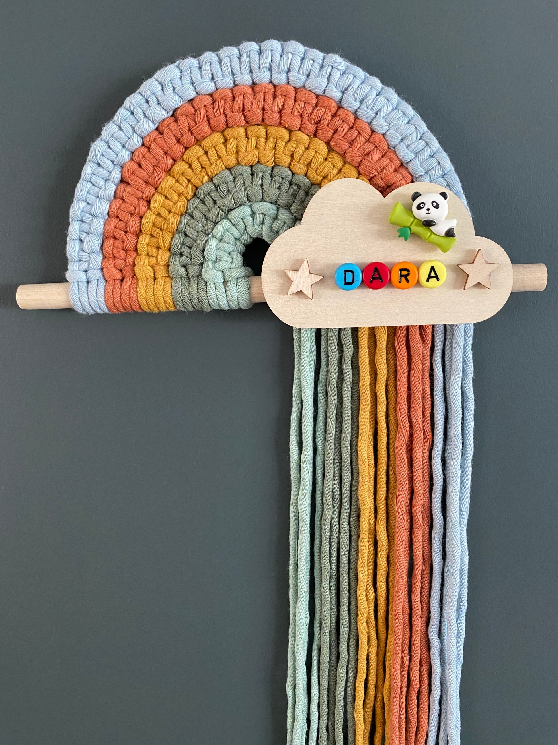 Colourful macramé rainbow on a wooden dowel with a personalised  wooden cloud plaque