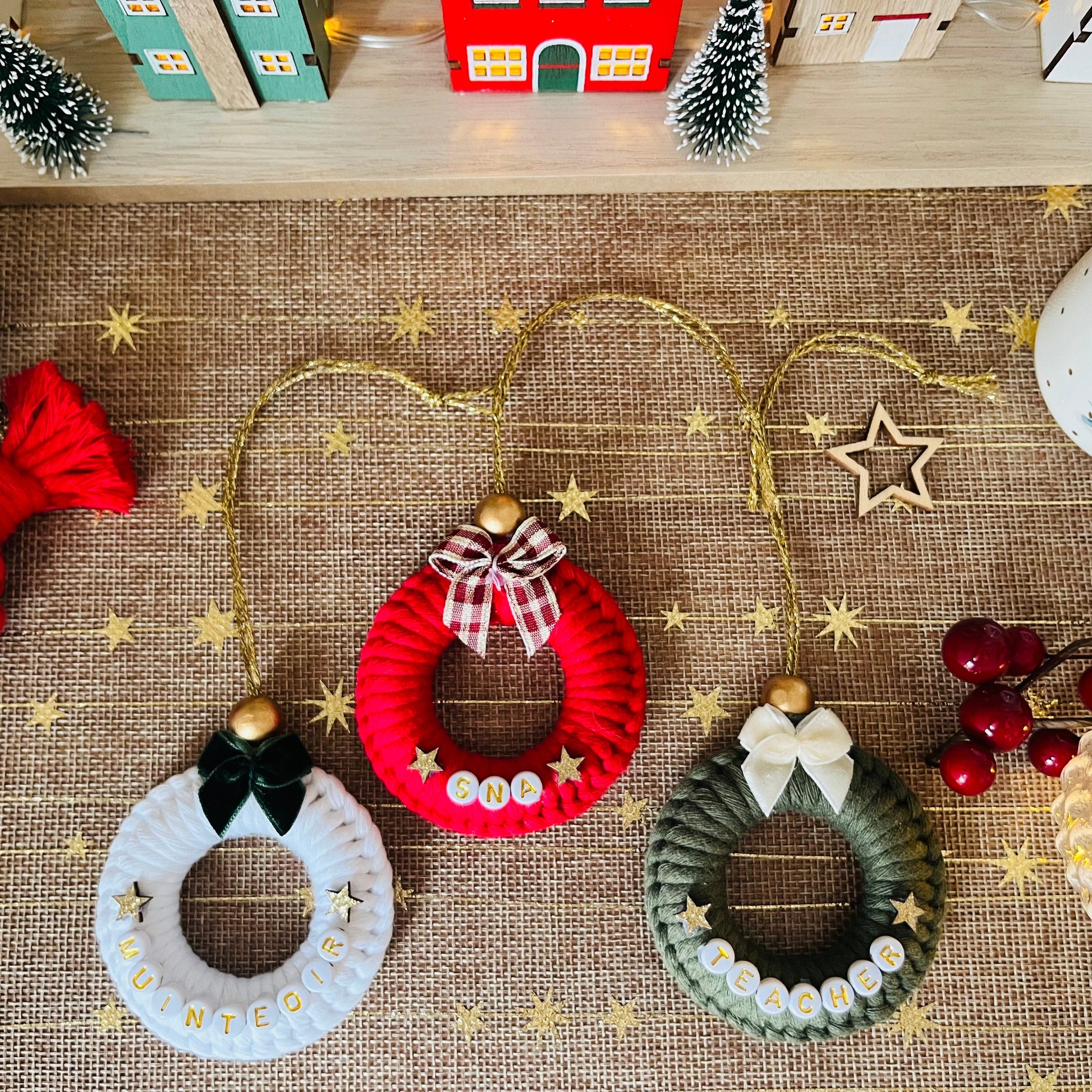 Decorative Christmas wreath ornaments on a textured surface with festive decorations.