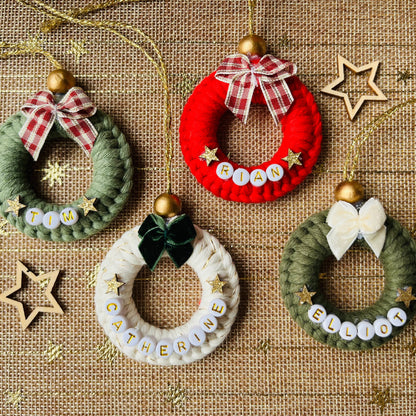 Set of small wreath ornaments with names on a textured fabric background