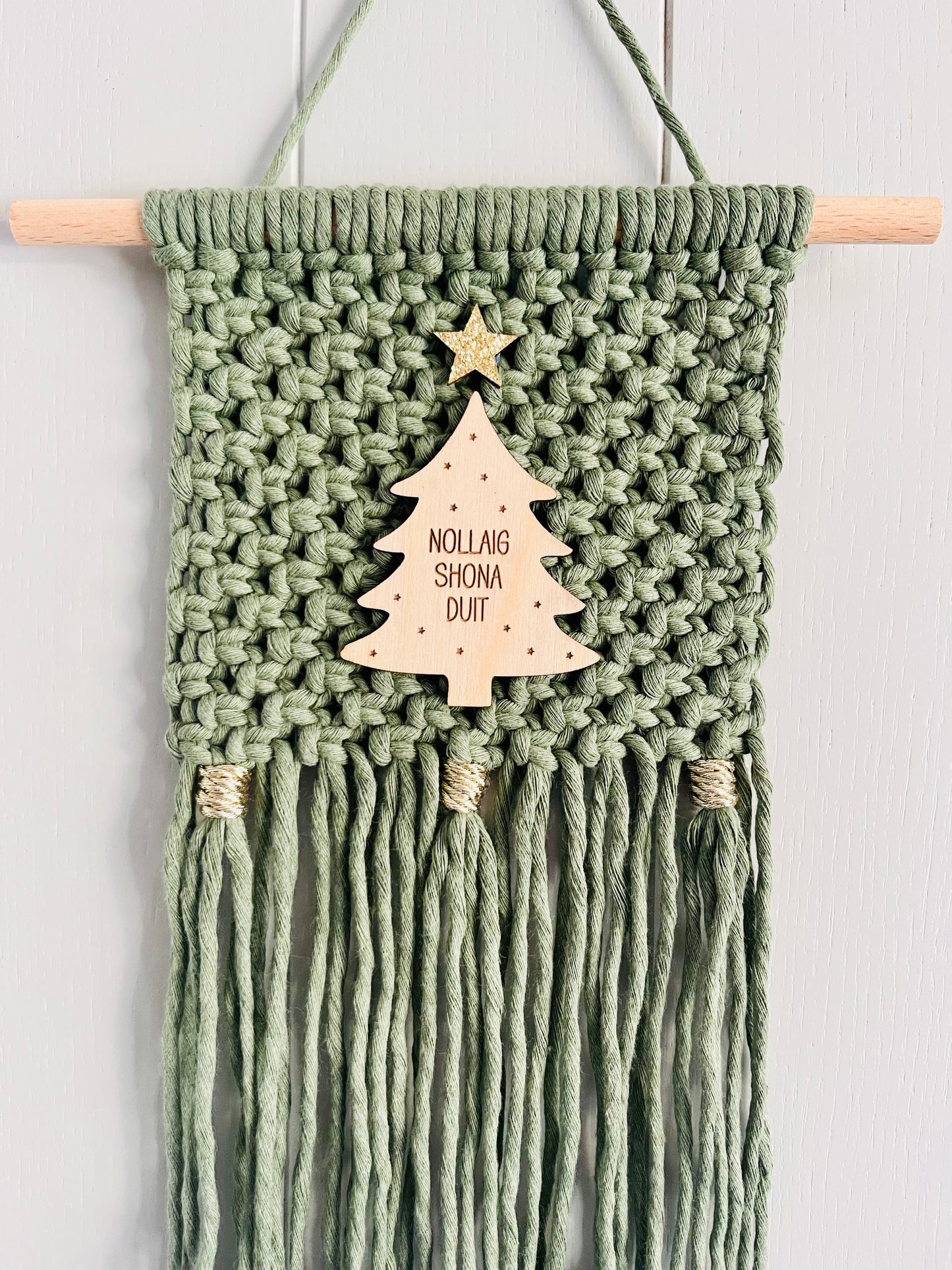 Macrame Christmas wall hanging in green with a wooden tree and gold accents