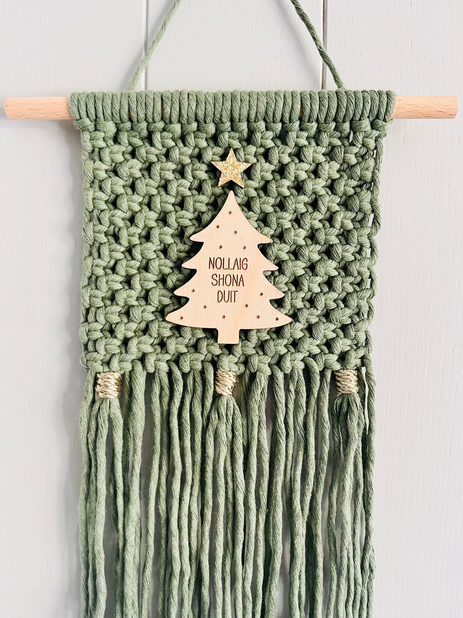 Macrame Christmas wall hanging in green with a wooden tree and gold accents