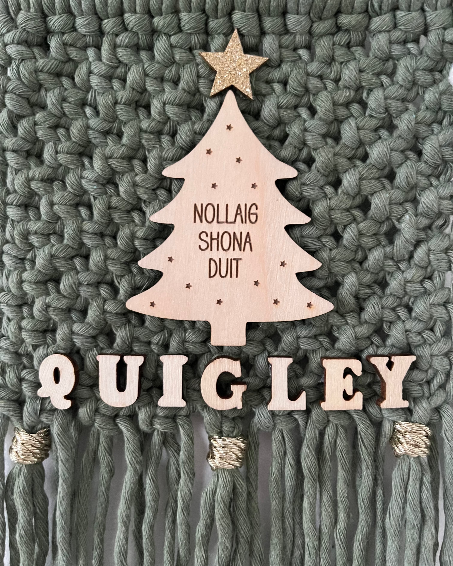 Macrame Christmas wall hanging in green with a wooden tree and gold accents