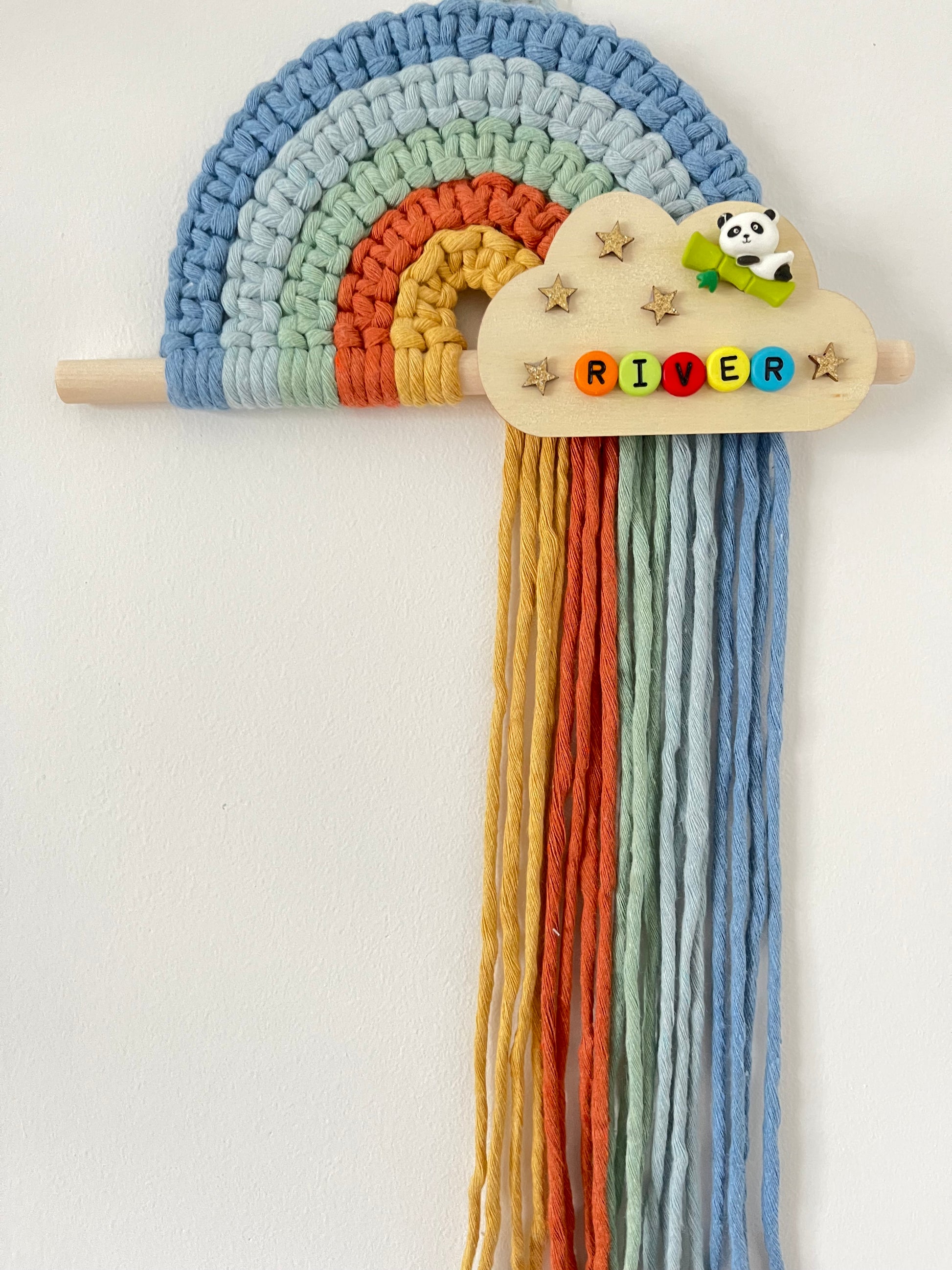 Colourful macramé rainbow on a wooden dowel with a personalised  wooden cloud plaque