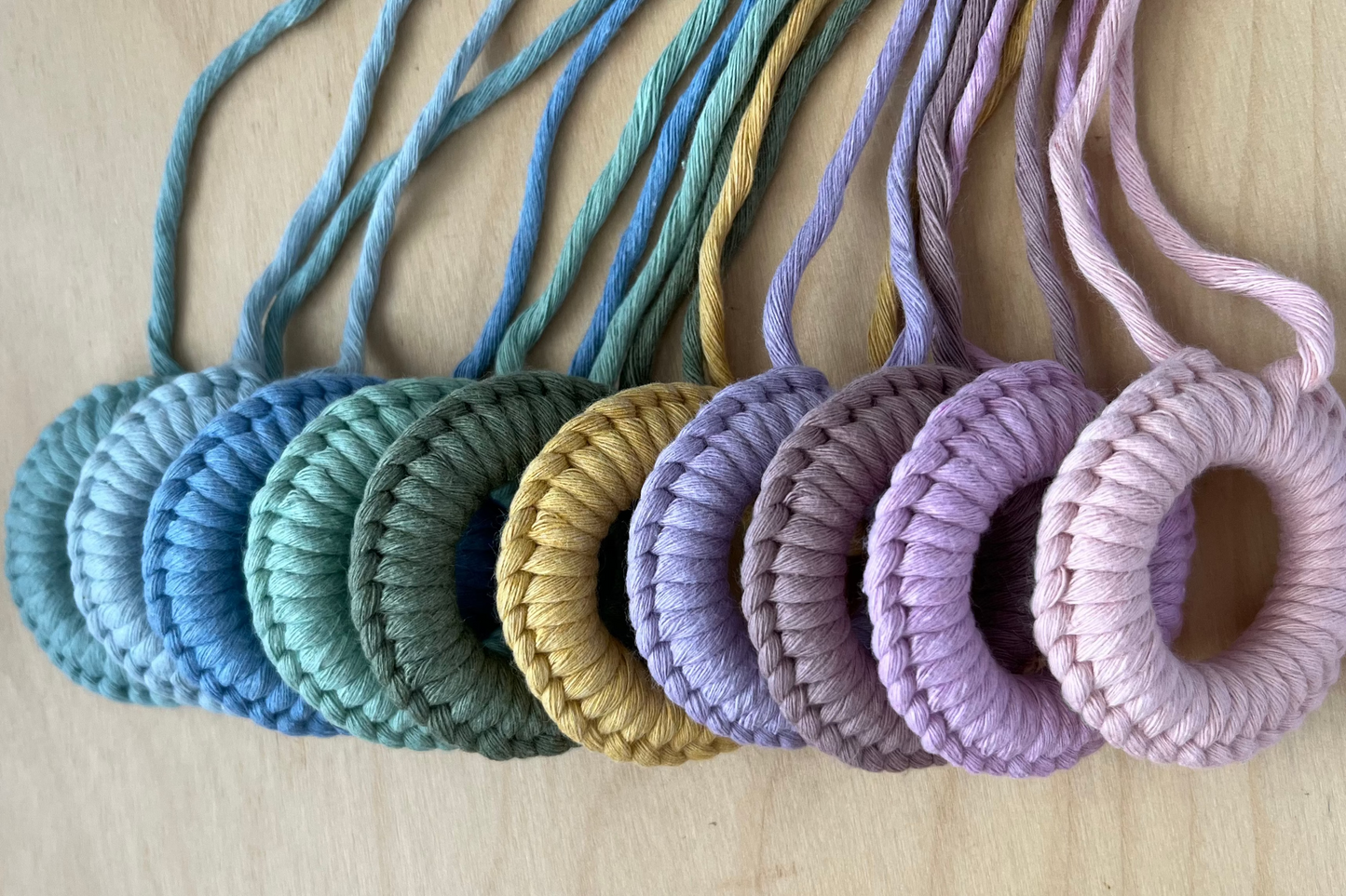 Stack of colorful yarn rings on a wooden surface