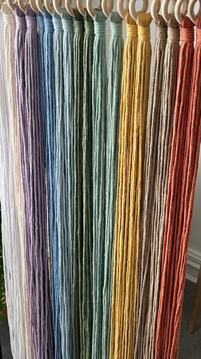 Colorful macrame cord strands hanging on a rack